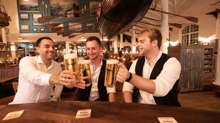 Drei Männer trinken ein Bier zusammen