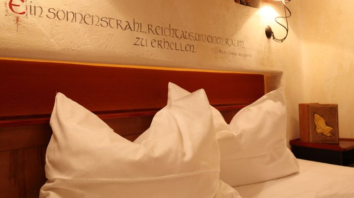 Standardzimmer Hotel Santa Isabel Schriftzug über Bett "Ein Sonnenstrahl reicht aus, um einen Raum zu erhellen."