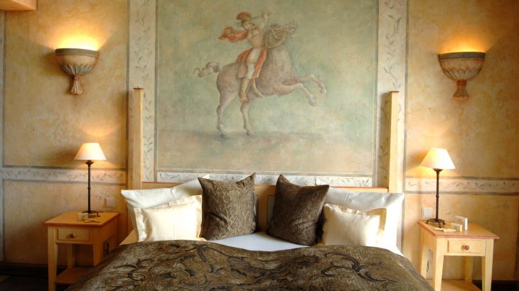 Suite Reale Hotel Colosseo Doppelbett mit Wandmalerei