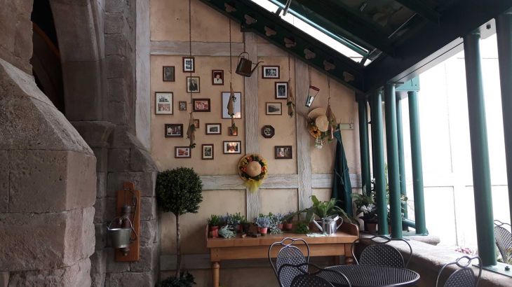 Dekorierte Wand mit Bildern und Hüten und Blumen