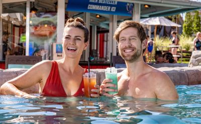 Ein Paar geniesst ihre Cocktails im Wasser