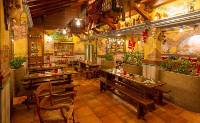 Groser Gastraum mit dunklen Bierbänken und Tischen