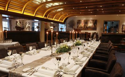 Eine schön eingedeckte lange Tafel mit Kerzenleuchtern auf den Tischen