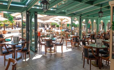 Blick aus dem offenen Cafe auf den sonnigen Platz Commedia dell Arte