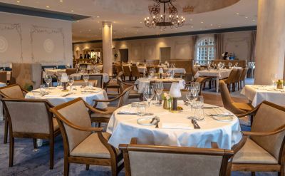 TRE KRØNEN Restaurant von innen mit runden gedeckten Tischen