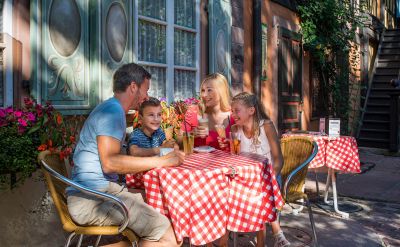 Chez Marianne von außen mit Familie an Tisch im Sommer