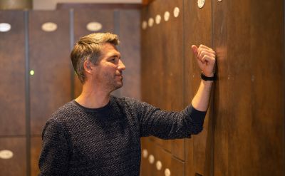 Mann öffnet ein Schließfach mit einem Rula-Band