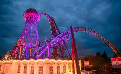 Die Achterbahn Voltron Nevera powered by Rimac in der Nacht mit pinker Beleuchtung.