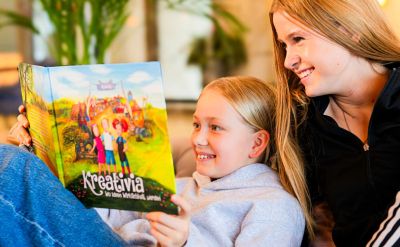 Kinder lesen das Buch Kreativia