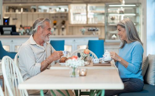Ein älteres Ehepaar sitzt mit Kaffee an einem Tisch