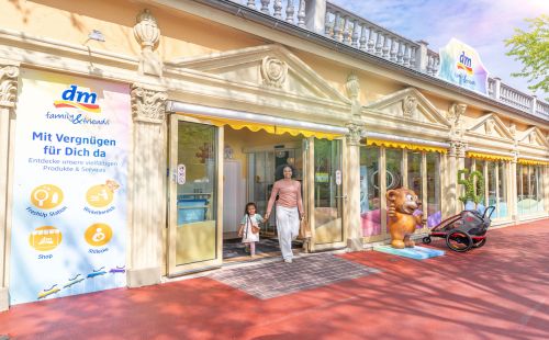 Mutter kommt mit Tochter aus dem dm family & friends Store