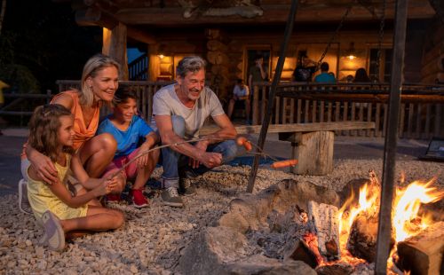 Senioren mit Enkelkindern am Lagerfeuer
