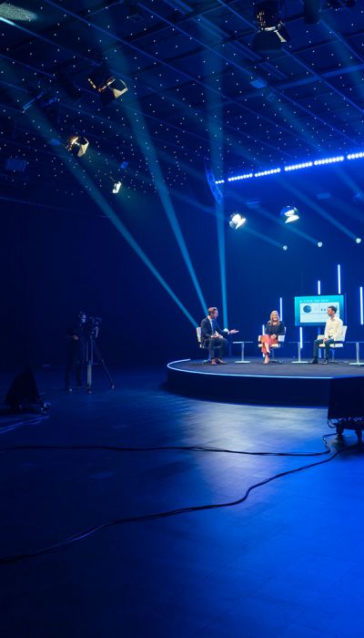 Ein moderator führt 4 Gäste durch eine Diskussion im Livestreaming-Studio