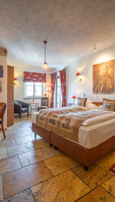Deluxe room with double bed, television, desk, chair and window