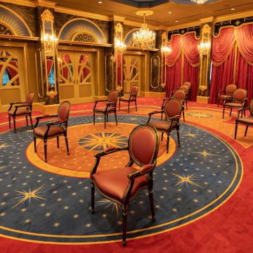 Veranstaltungsraum mit mehreren Stühlen weit auseinander gestellt