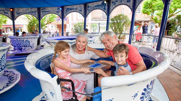 Familie fährt in Koffiekopjes-Tassen