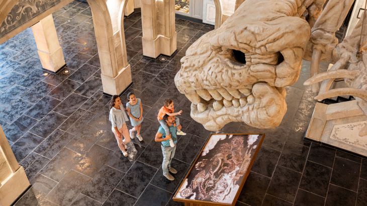 Eine Familie bewundert das mächtige Skelett von Svalgur in der Lobby des Hotels "Krønasår"