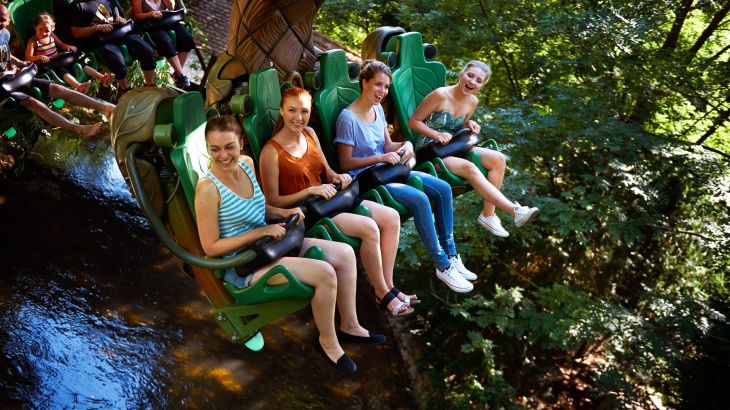 Besucherinnen hängen in ihrem Sitz über einem Fluss