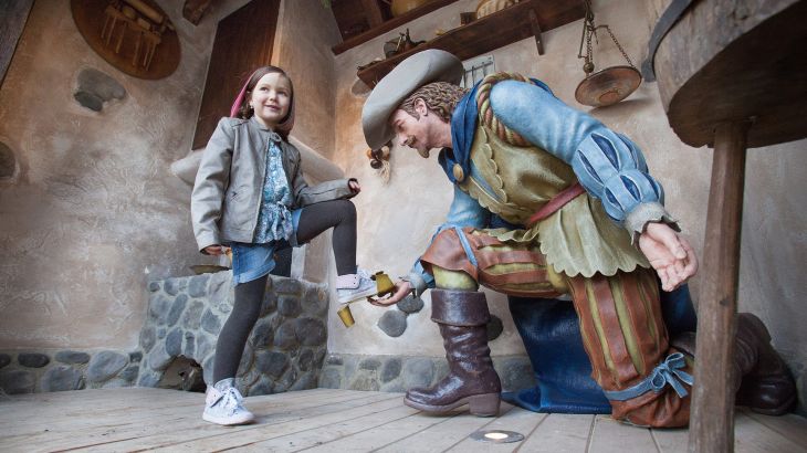 Mädchen probiert den goldenen Schuh des Prinzen an