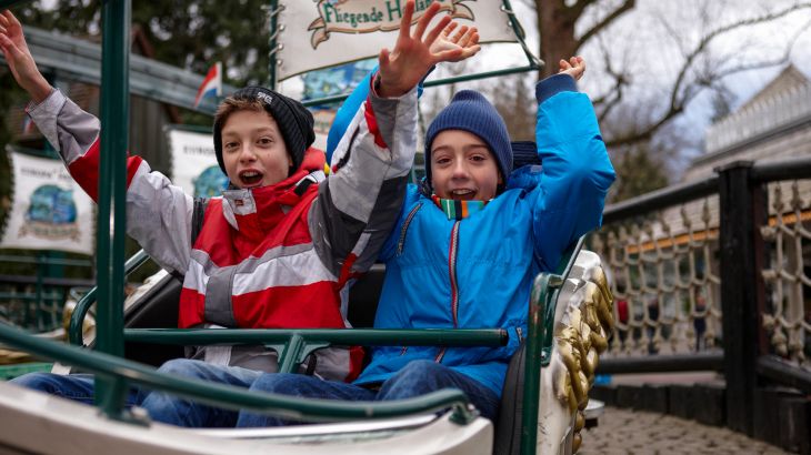 Kinder in einem der Boote des Fliegenden Holländers, sie heben ihre Hände in die Luft