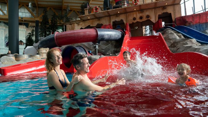 Kinder rutschen Överstor hinunter, die Eltern warten am Ende der Wasserrutsche