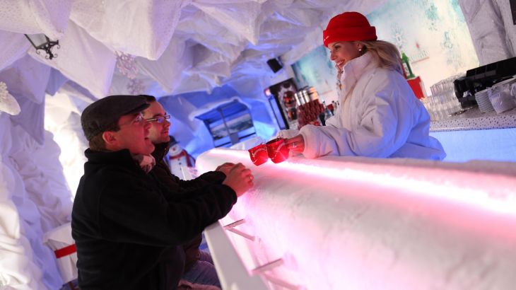 Dei Bedienung überreicht Glühwein an die Gäste der Bar Glaciar in Spanien