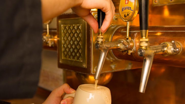 Im Bierkeller wird grade ein frisches Bier am Zapfhahn gezapft