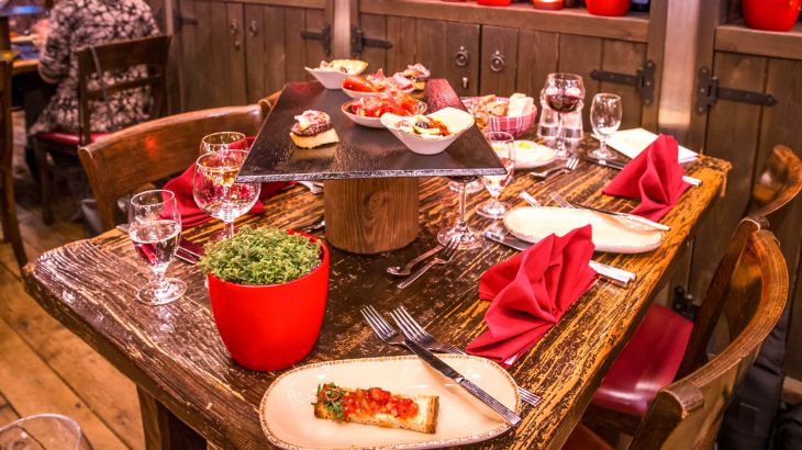 Ein gedeckter Tisch mit Tapas und Gedecke mit roten Servietten