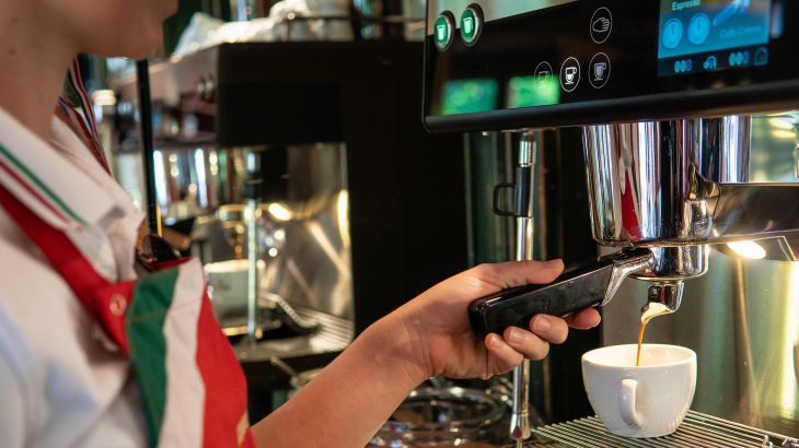 Ein Kaffee wird frisch mit einer Siebdruckmaschiene zubereitet