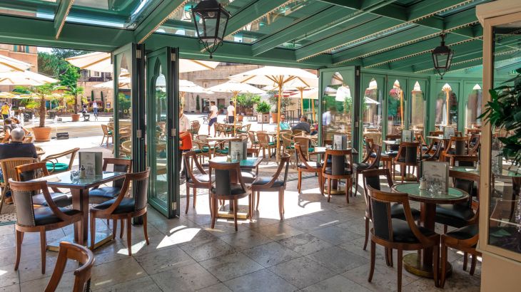 Blick aus dem offenen Cafe auf den sonnigen Platz Commedia dell Arte