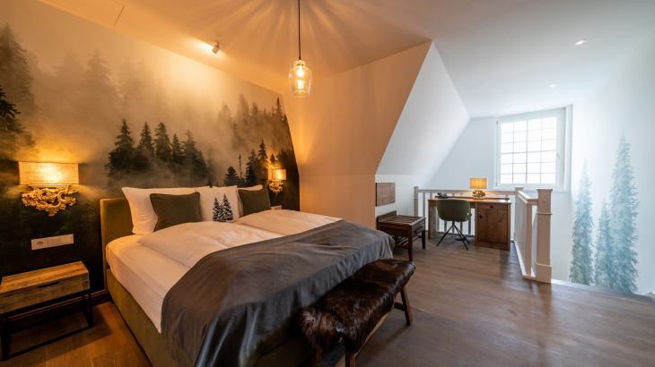 Duplex Themensuite Nordman Hotel Krønasår Doppelbett mit Schwarzwald Wandgemälde, Schreibtisch mit Stuhl