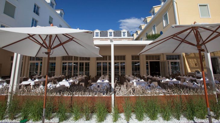 Überdachte Terrasse des Haborside Restaurant mit zwei großen Sonnenschirmen im Vordergrund