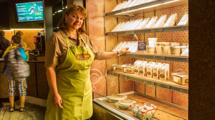 Verkäuferin vor einem Regal mit frischen Sandwiches