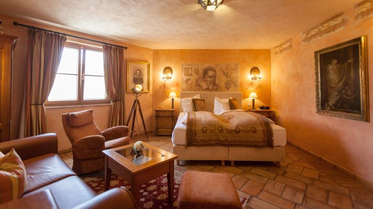 Juniorsuite Hotel Colosseo Doppelbett, Couch, Stuhl und Tisch mit Fenster