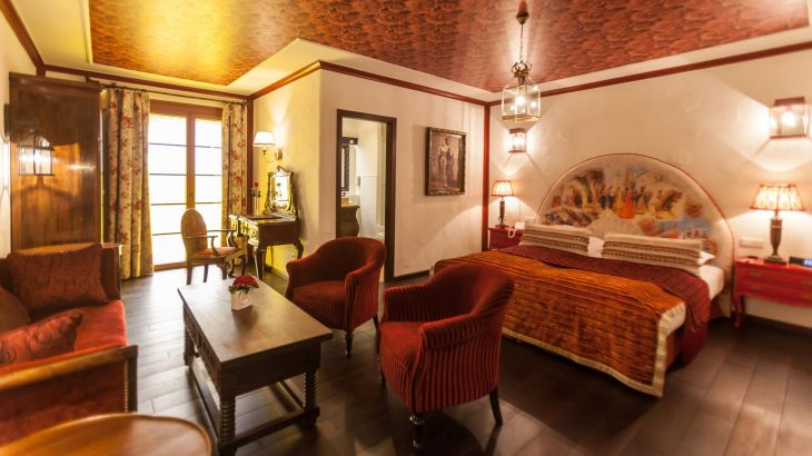 Juniorsuite Hotel El Andaluz Wohn- und Schlafzimmer mit Doppelbett, Tisch und Sitzmöglichkeiten