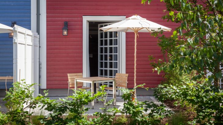 Komfort-Zimmer Hotel Krønasår Terasse mit Stühlen und Sonnenschirm