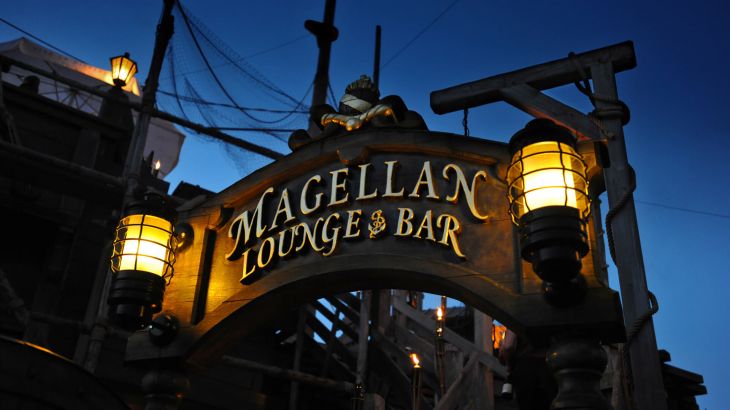 Das Schild Magellan Lounge & Bar am Eingang ist mit zwei Laternen beleuchtet