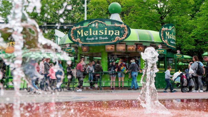 Melusina Snacks & Drinks mit Wasserfontainen im Vordergrund