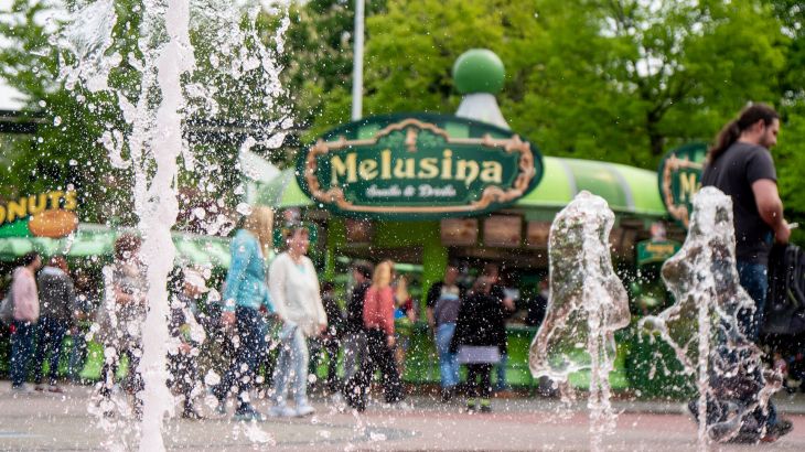 Melusina Snacks & Drinks mit Wasserfontainen im Vordergrund