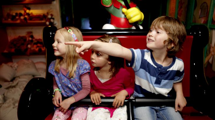 Kinder fahren im Piccolo Mondo, ein Junge zeigt mit seinem Finger nach Links