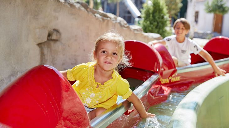 Kinder fahren mit den Paddelbooten durch einen Kanal