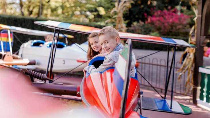 Kinder sitzen in rotem Flugzeug