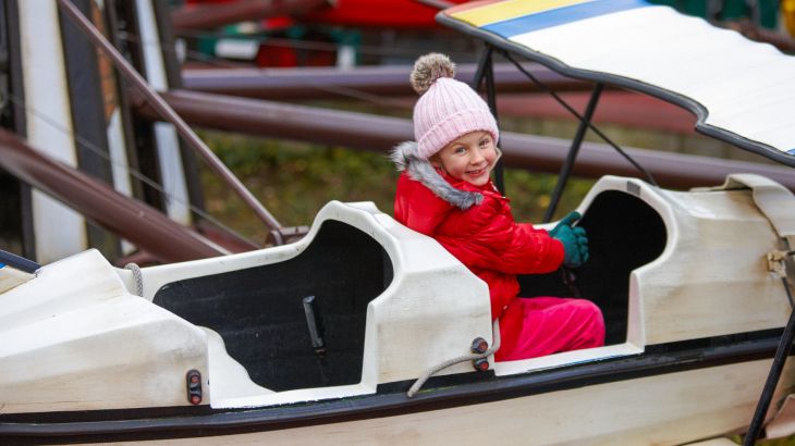 Kind sitzt in weißem Flugzeug des Roten Barons