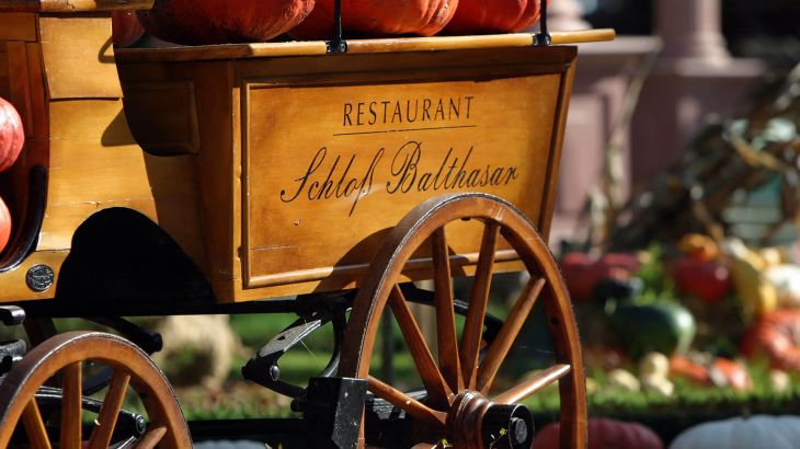 Restaurant Schloss Balthasar Holzwagen mit Kürbissen beladen