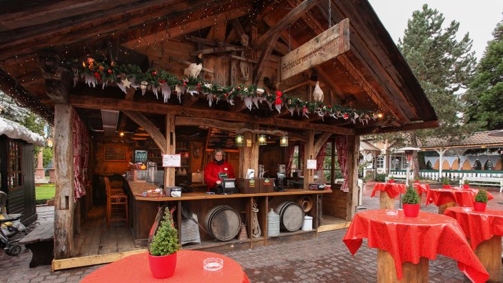 Schwarzwaldstüble von außen mit Stehtischen mit roten Tischdecken davor