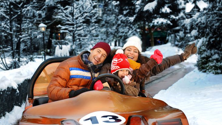 Familie fährt im Rennwagen auf der Silverstone-Piste, im Hintergrund liegt Schnee