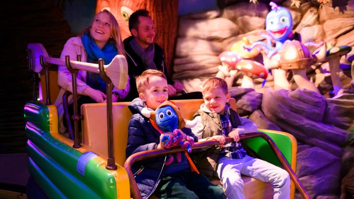 Familie im Wagen von "Snorri Touren", im Hintergrund ist eine Figur von Snorri, eines der Kinder hat ein Snorri-Plüschtier