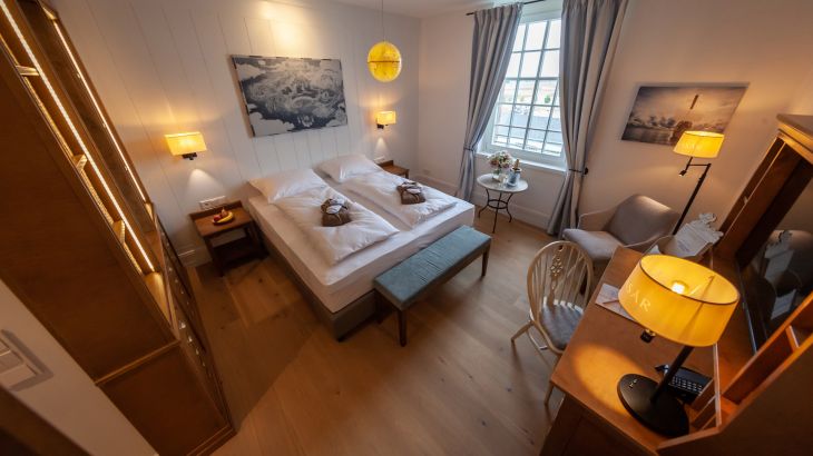 Standaardkamer Plus hotel Krønasår slaapkamer, venster, tafel en stoel