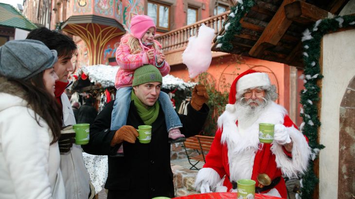 Gäste trinken mit dem Weihnachtsmann einen Glühwein