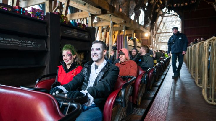 Besucher im Halloweenkostüm beim Start der Achterbahn